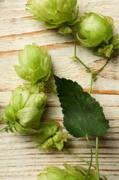 Fresh green hops on white wooden table, flat lay