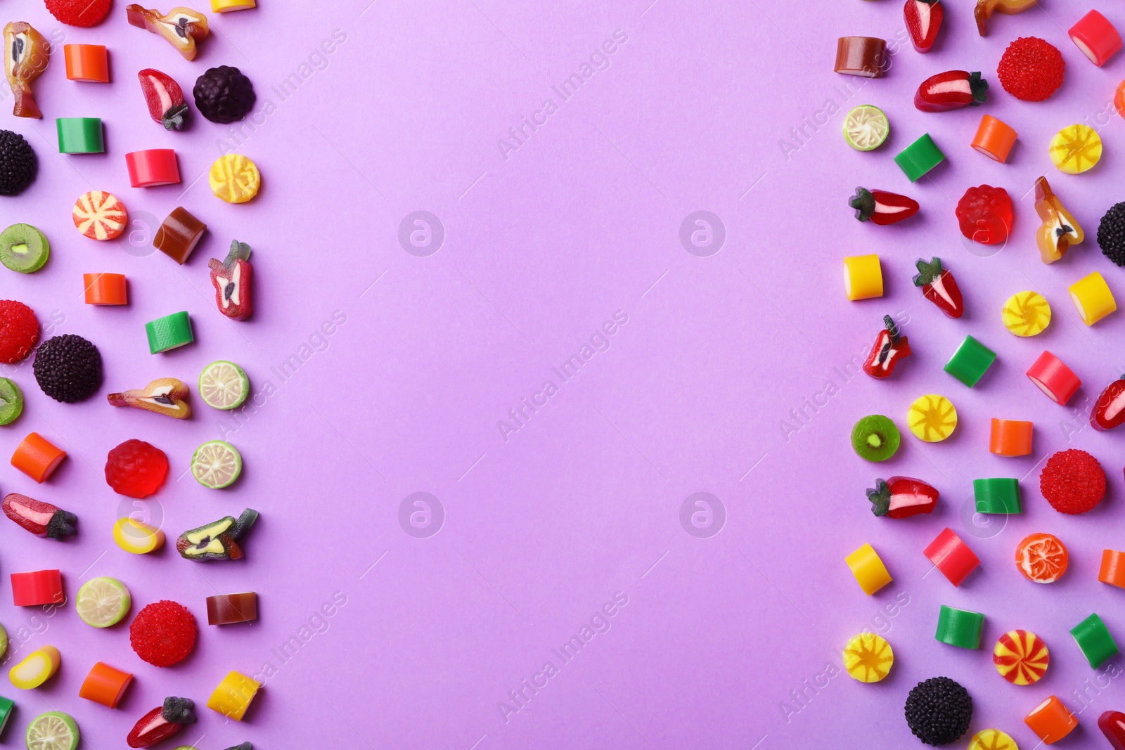 Photo of Flat lay composition with delicious colorful candies and space for text on color background