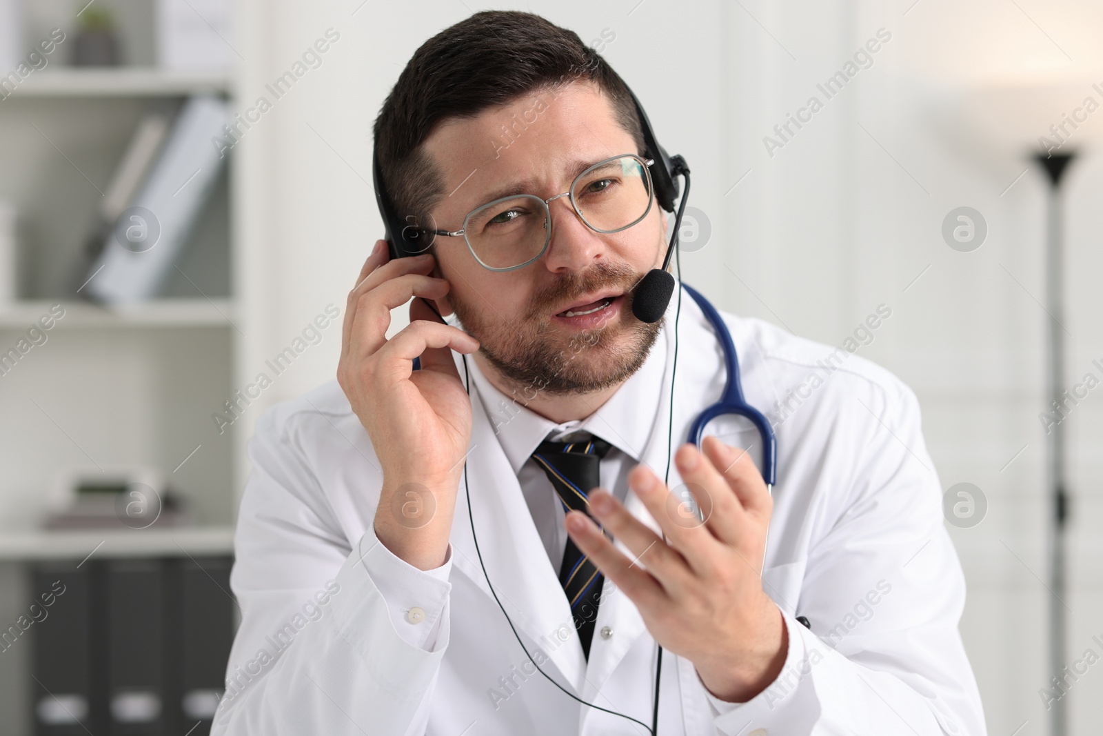 Photo of Doctor in headset having online consultation in clinic
