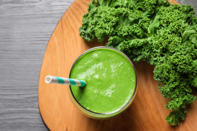 Photo of Tasty kale smoothie on light grey wooden table, flat lay