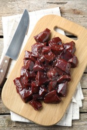 Photo of Cut raw beef liver on wooden table, top view