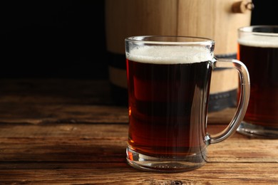 Glass mug of delicious kvass on wooden table. Space for text