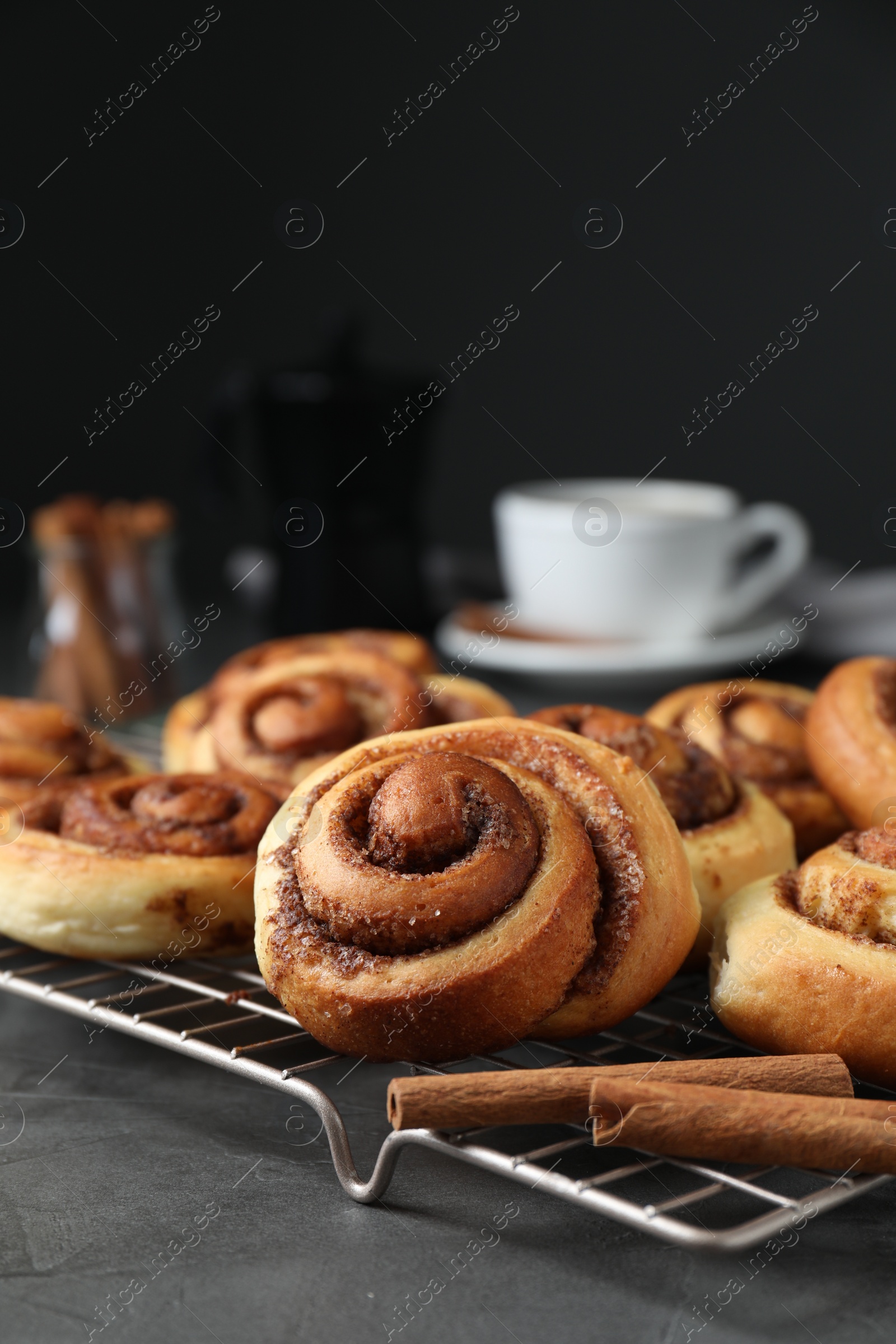 Photo of Tasty cinnamon rolls on black table, space for text