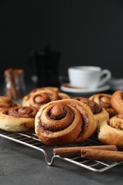 Tasty cinnamon rolls on black table, space for text