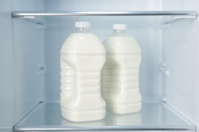 Photo of Gallons of fresh milk in refrigerator, closeup