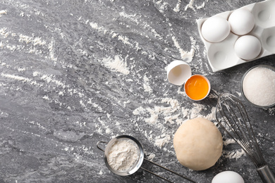 Flat lay composition with dough on grey table, space for text. Cooking pastries