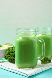 Photo of Tasty fresh kale smoothie on light blue wooden table