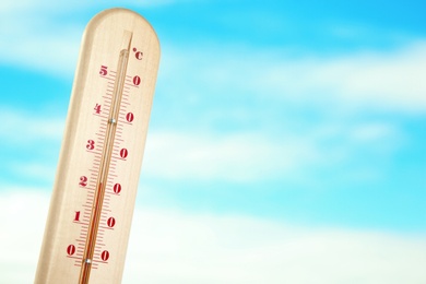 Photo of Weather thermometer and blue cloudy sky on background. Space for text