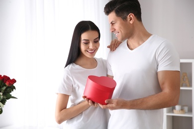 Lovely couple with gift box at home. Valentine's day celebration