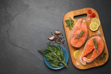 Photo of Fresh salmon and ingredients for marinade on black table, flat lay. Space for text
