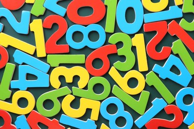 Colorful numbers on green background, top view