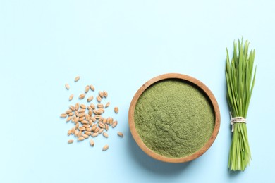 Photo of Wheat grass powder in bowl, seeds and fresh sprouts on light blue background, flat lay