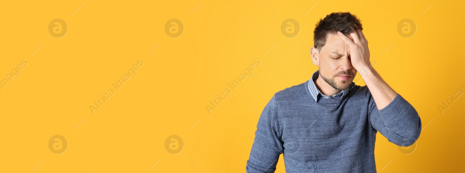 Image of Man suffering from terrible migraine on yellow background, space for text. Banner design