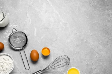 Photo of Ingredients for crepes, whisk and sieve on light grey table, flat lay. Space for text