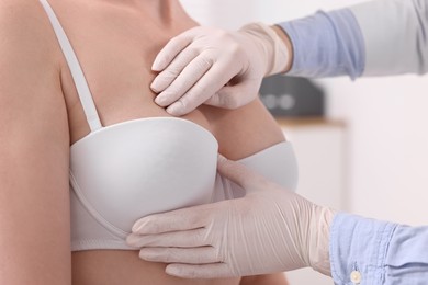 Mammologist checking woman's breast in hospital, closeup