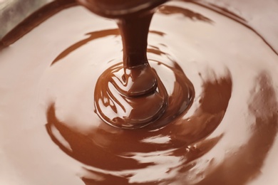 Pouring delicious melted milk chocolate, closeup