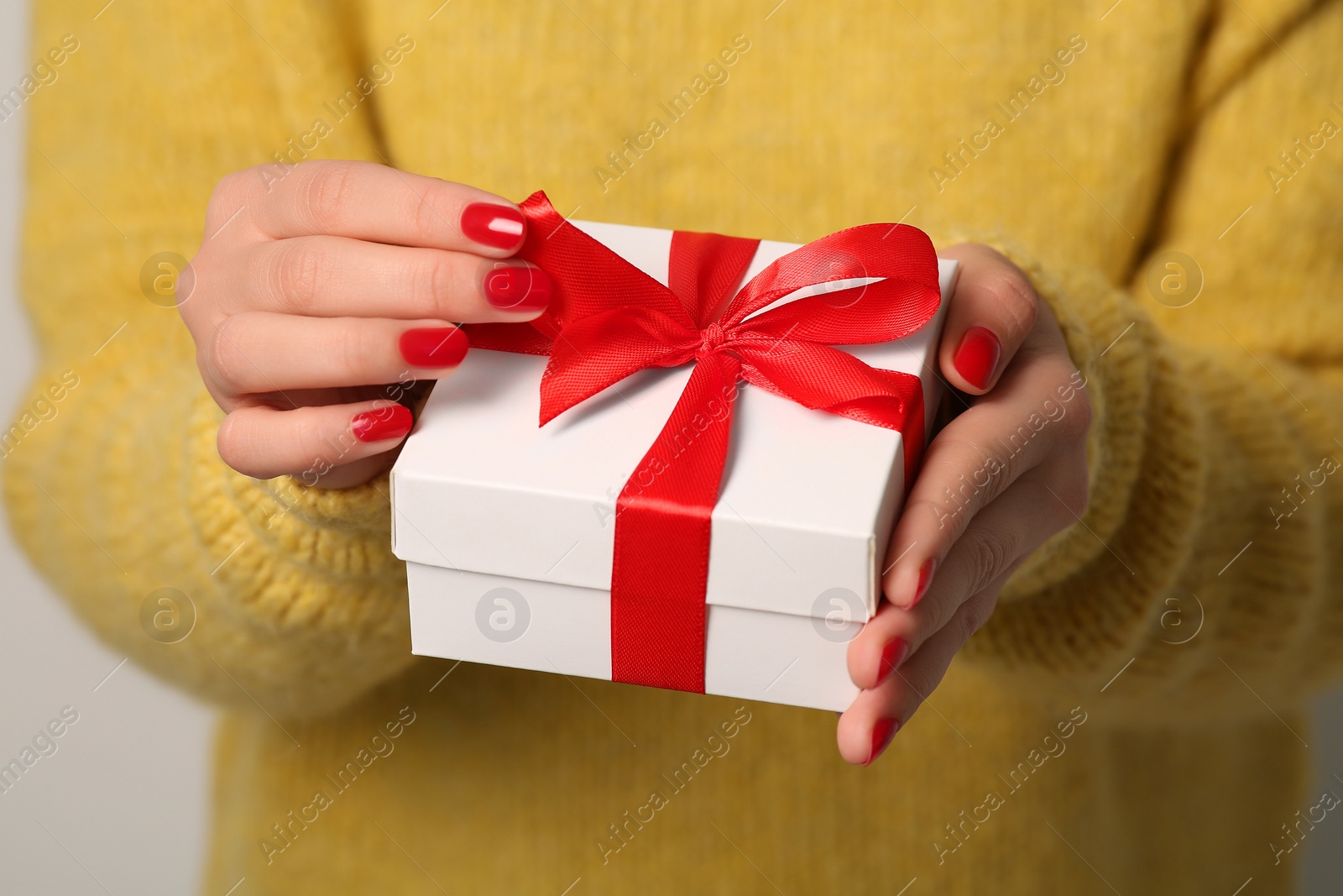 Photo of Christmas present. Woman holding gift box, closeup