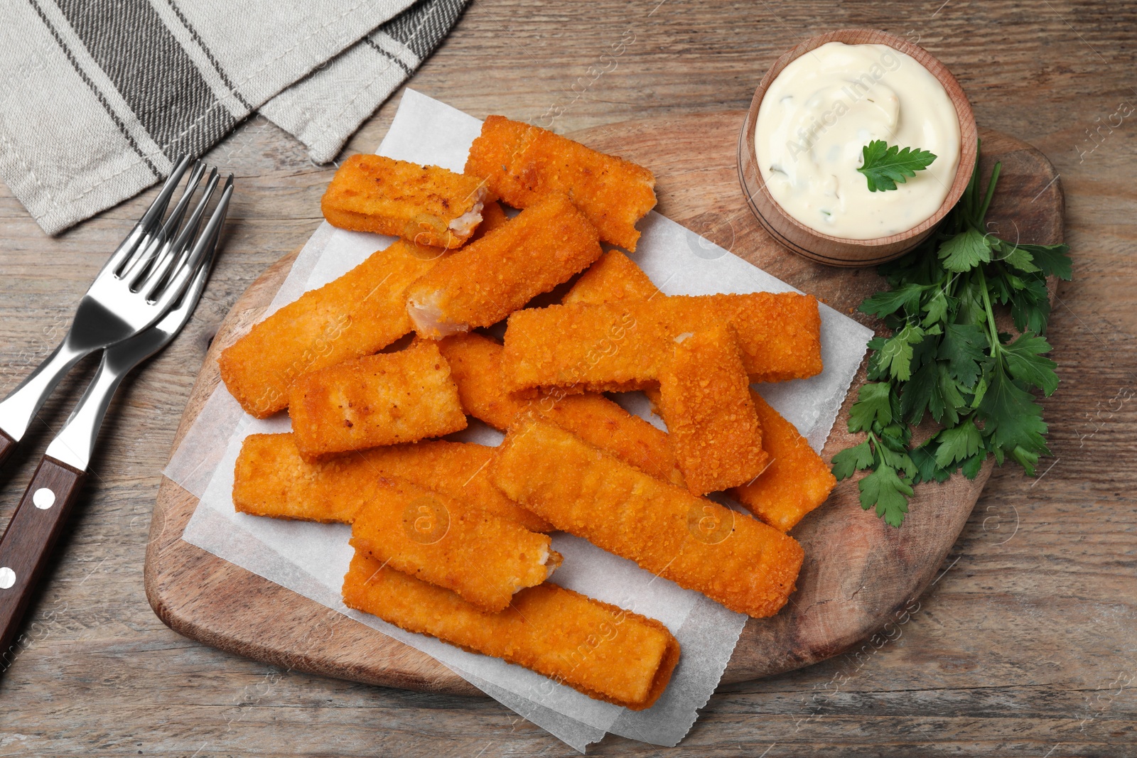 Photo of Tasty fresh fish fingers served on wooden table, flat lay