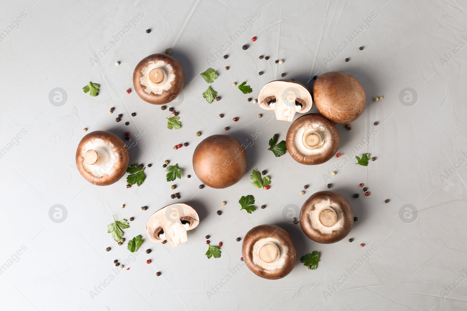 Photo of Flat lay composition with fresh champignon mushrooms on grey background