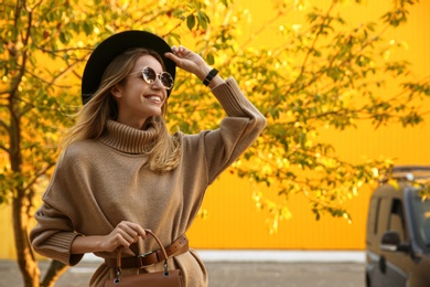 Photo of Beautiful young woman wearing stylish autumn clothes in park