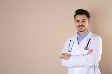 Young medical student in uniform on color background. Space for text