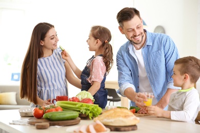 Photo of Happy family with children having breakfast in kitchen