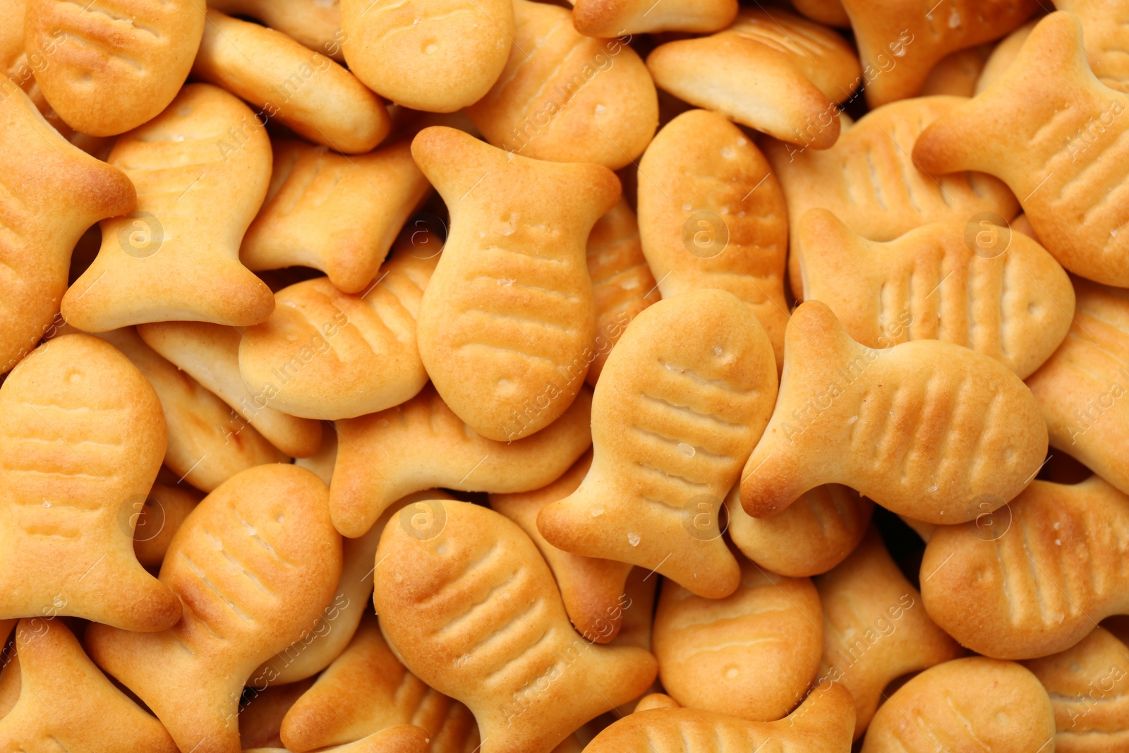 Photo of Delicious goldfish crackers as background, closeup view