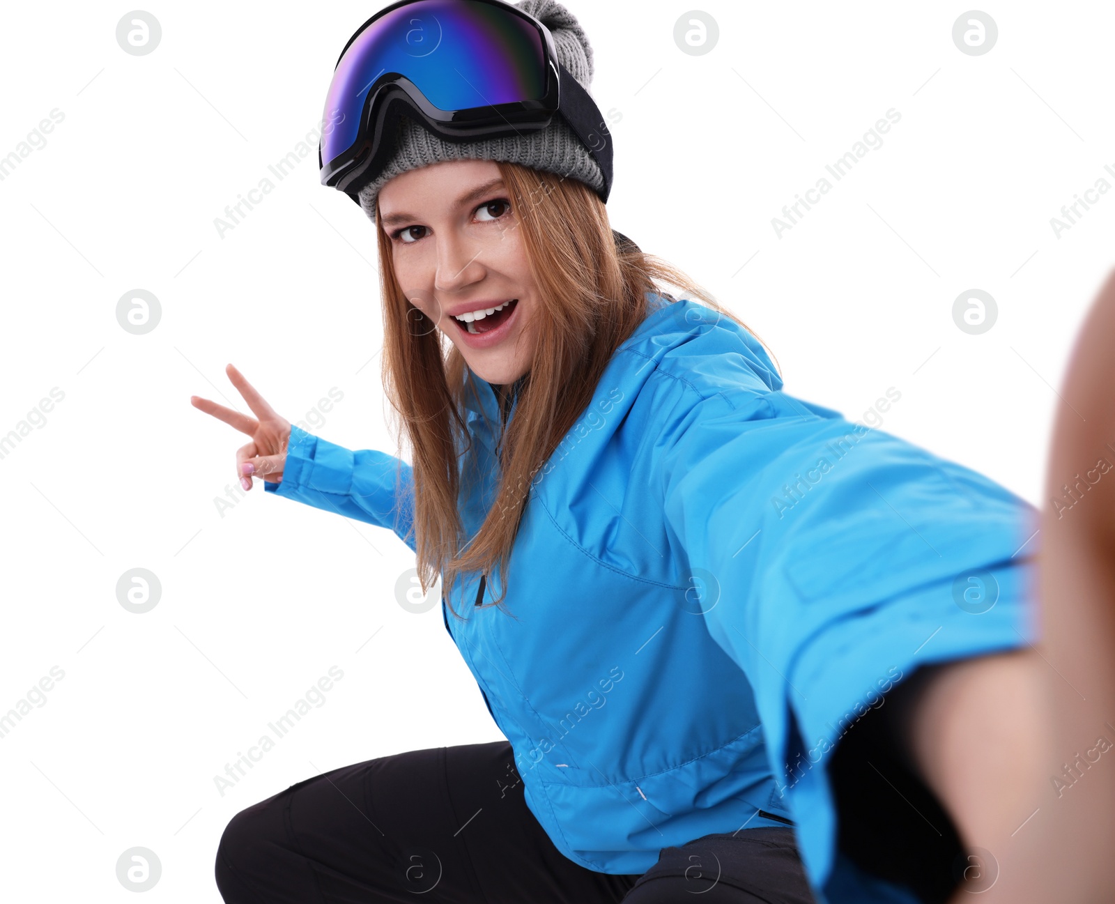 Photo of Beautiful woman in ski goggles taking selfie on white background