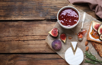 Photo of Flat lay composition with delicious fig jam on wooden table. Space for text