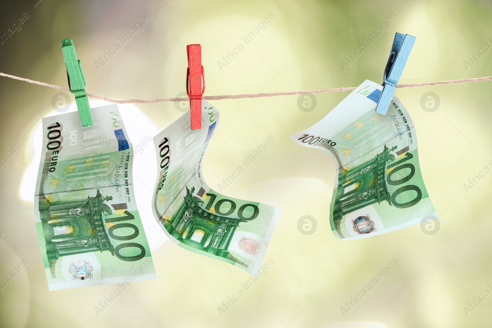 Image of Money laundering. Euro banknotes hanging on clothesline against blurred background