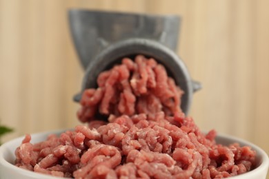 Photo of Mincing beef with manual meat grinder on blurred background, closeup