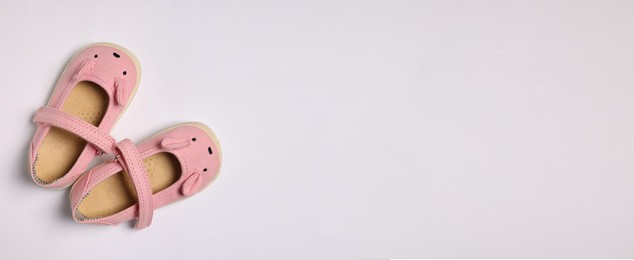 Image of Cute baby shoes on white background, top view. Banner design with space for text