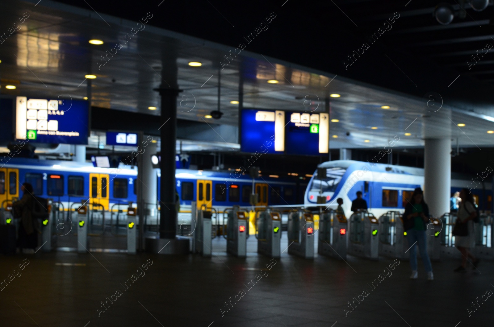 Photo of Blurred view of railway station with platforms at night