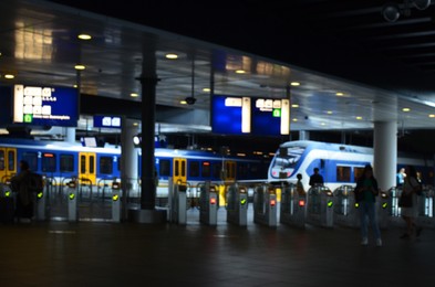 Photo of Blurred view of railway station with platforms at night