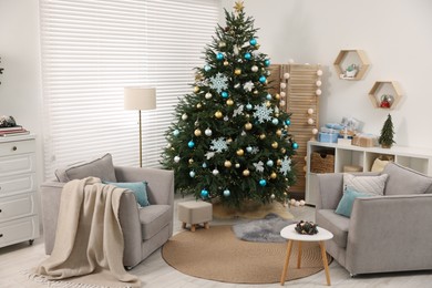 Photo of Christmas tree in room decorated for holiday. Festive interior design
