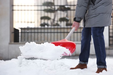 Man removing snow with shovel outdoors, closeup