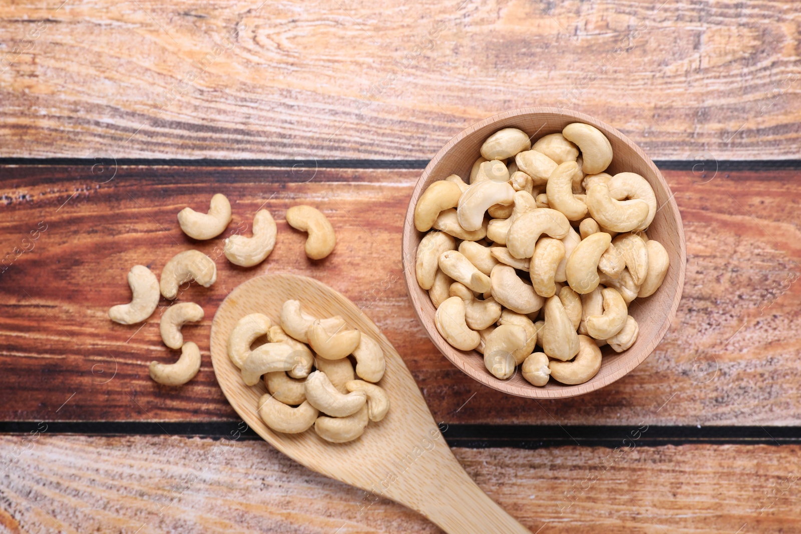 Photo of Tasty cashew nuts on wooden table, flat lay