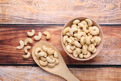 Photo of Tasty cashew nuts on wooden table, flat lay