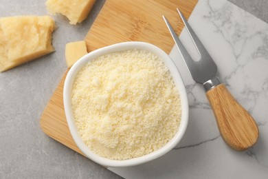 Photo of Parmesan cheese with fork on grey table, flat lay