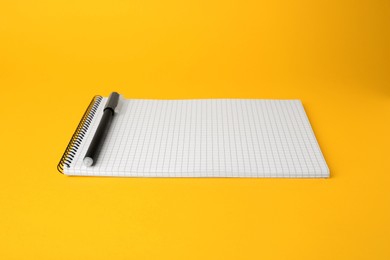 Photo of Notepad with erasable pen on yellow background