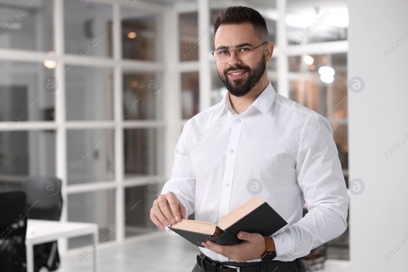 Photo of Portrait of smiling man with book in office, space for text. Lawyer, businessman, accountant or manager