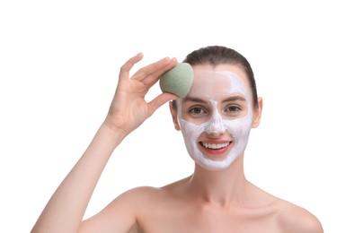 Photo of Happy young woman washing off face mask with sponge on white background