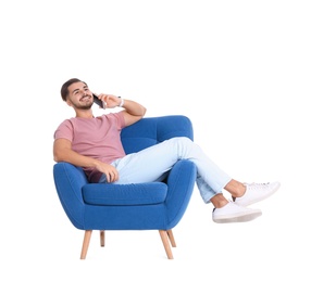 Photo of Handsome young man talking on phone in armchair against white background