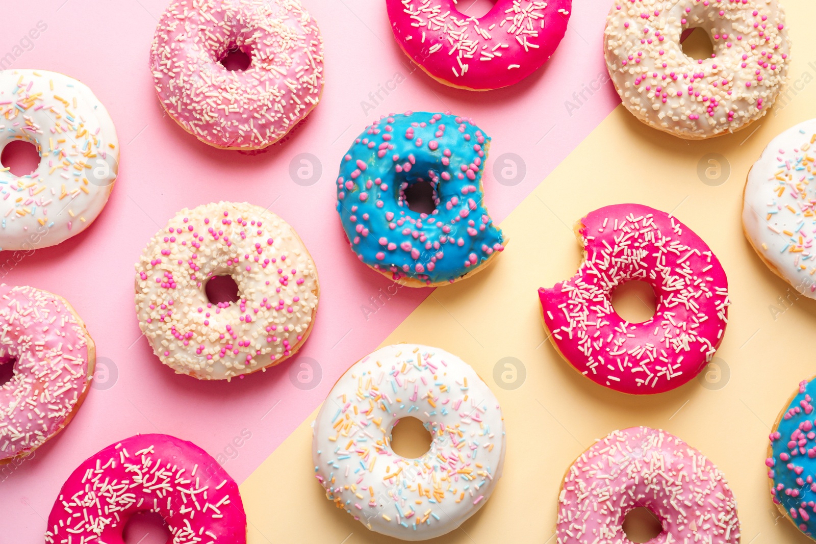 Photo of Delicious glazed doughnuts on color background, top view