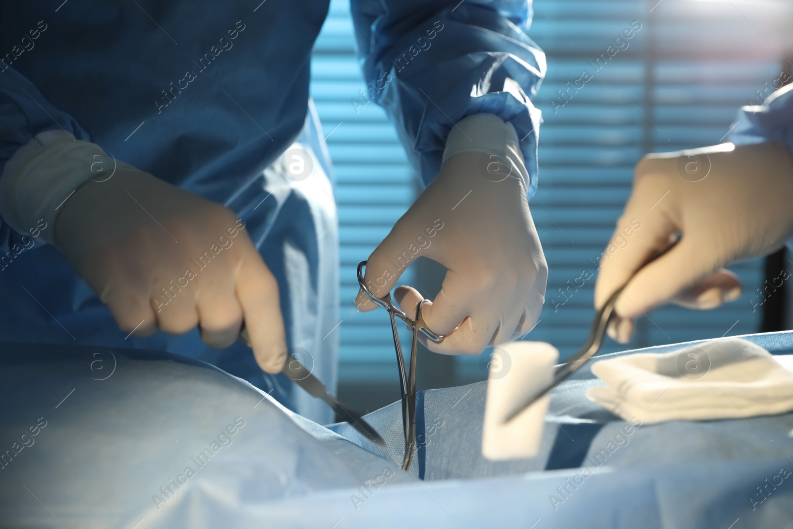 Photo of Professional surgeons with instruments performing operation in clinic, closeup