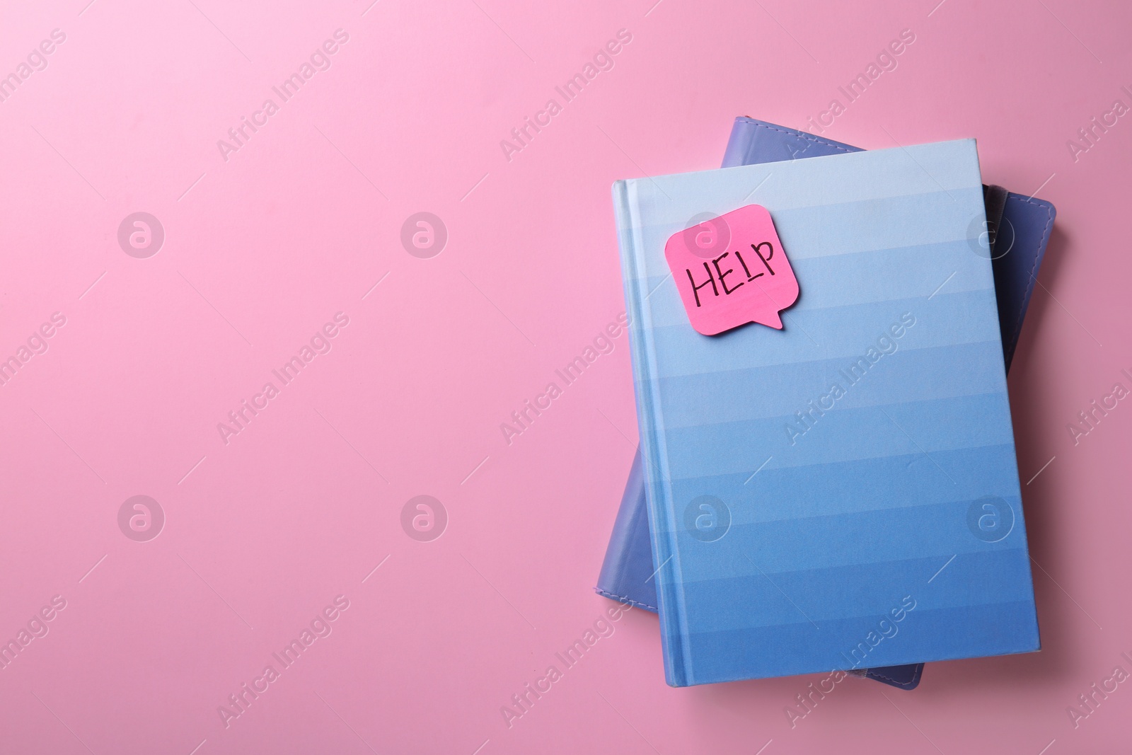 Photo of Notebooks and sticker with word HELP on color background, top view. Space for text