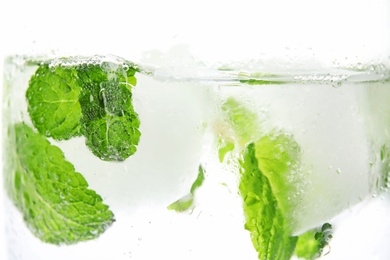 Photo of Drink with mint and ice cubes in glass on white background, closeup