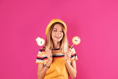 Young pretty woman with candies on colorful background