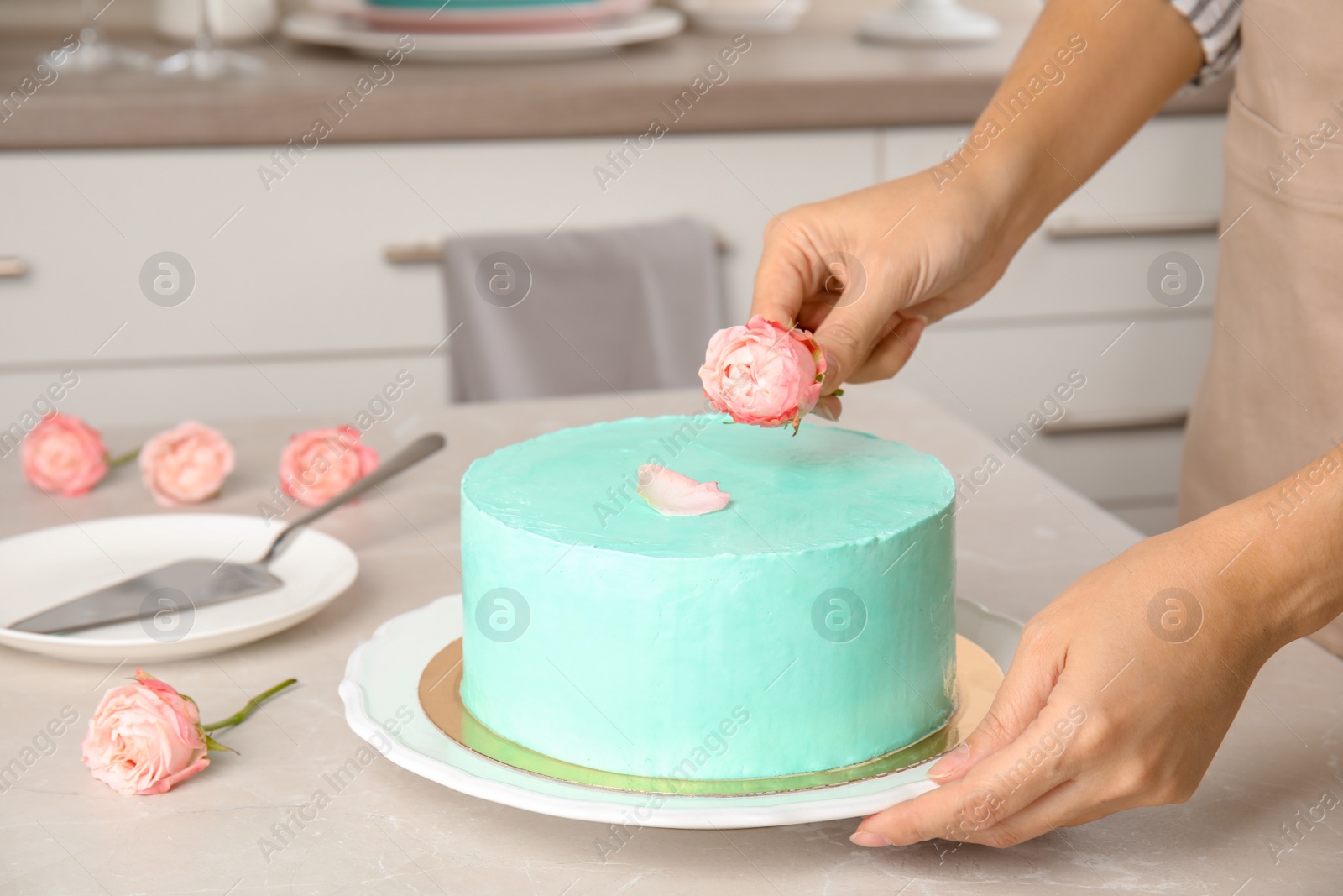 Photo of Woman decorating fresh delicious birthday cake in kitchen, closeup