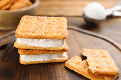 Sweet delicious ice cream cookie sandwiches on wooden board, closeup